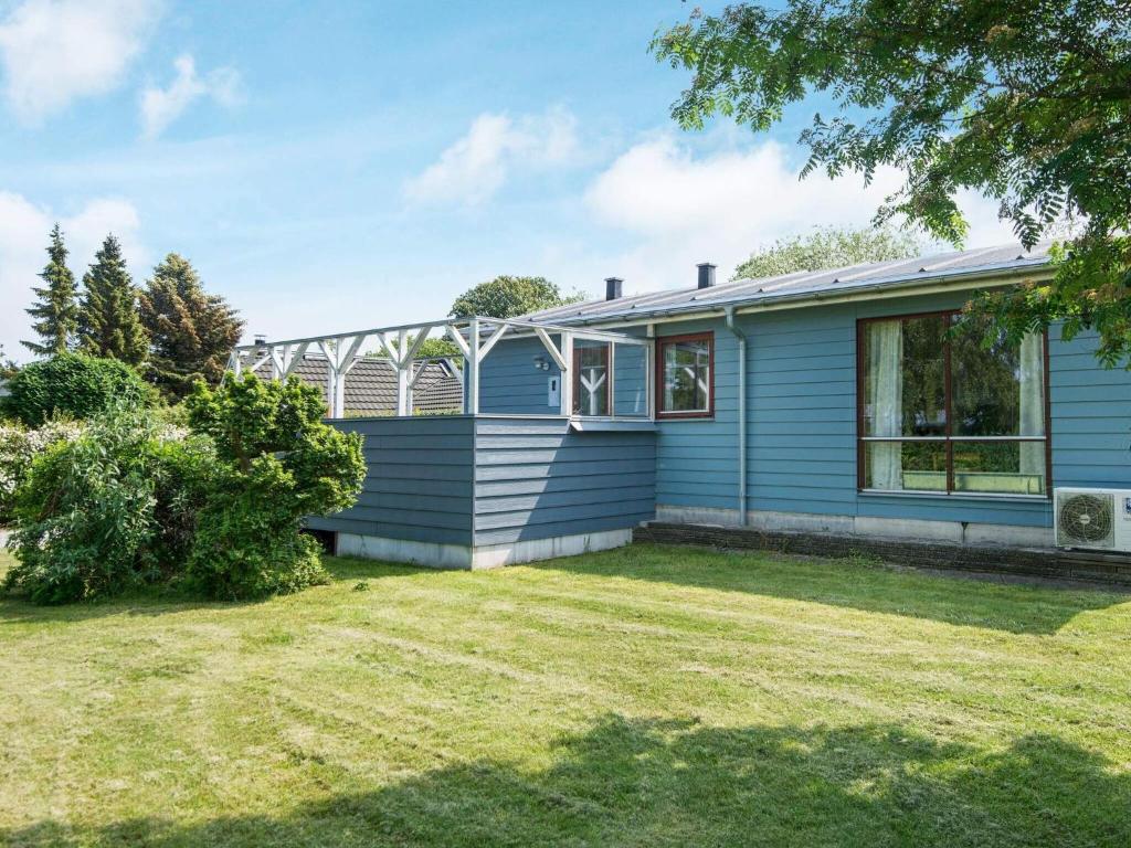 a blue house with a yard in front of it at 4 person holiday home in Juelsminde in Snaptun