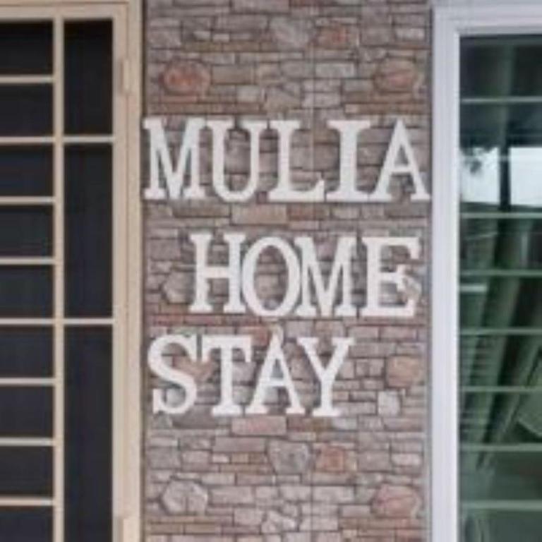 a brick wall with a sign that says mulha home stay at mulia homestay in Teluk Intan