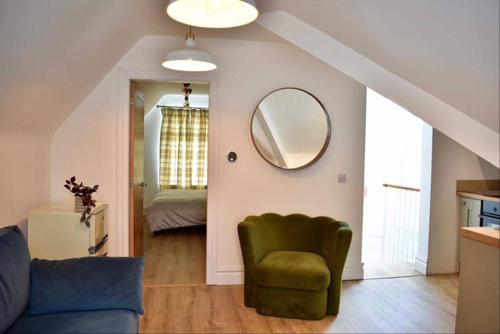 a living room with a green chair and a mirror at Stylish Modern Flat in Doncaster Centre in Doncaster