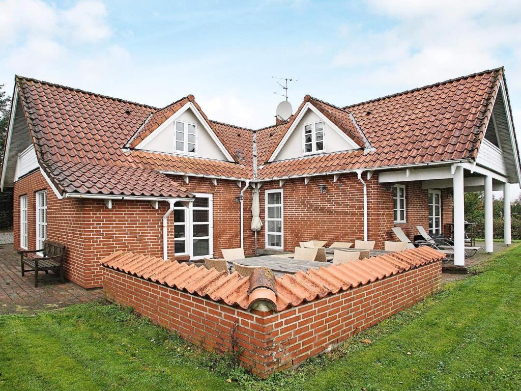 a red brick house with a brick wall at 10 person holiday home in Fur-By Traum in Fur