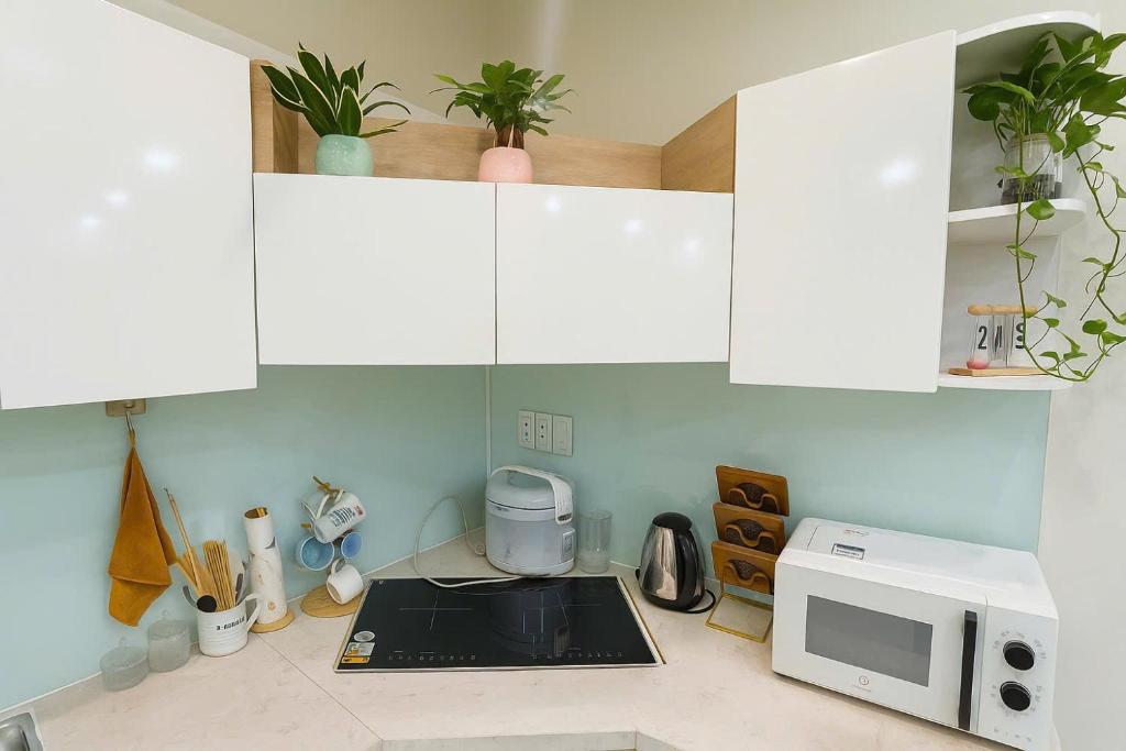 une cuisine avec des armoires blanches et un micro-ondes dans l'établissement SeaLavie, à Đà Nẵng