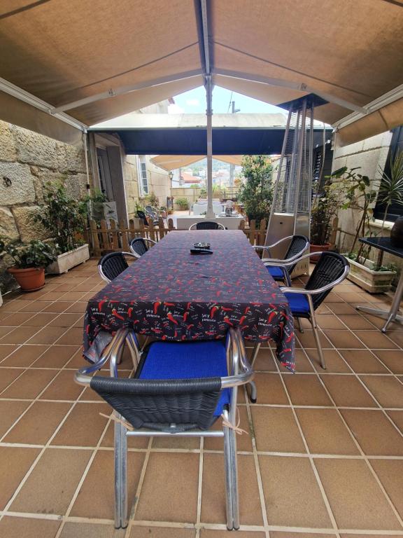 a table and chairs under an umbrella on a patio at La Casona in Redondela