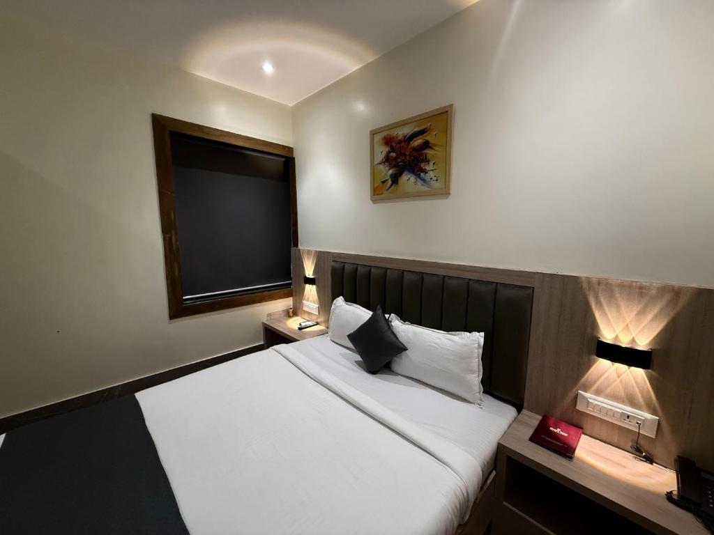 a bedroom with a large bed and a television at Hotel Riza - Near Nesco Exhibition Centre in Mumbai