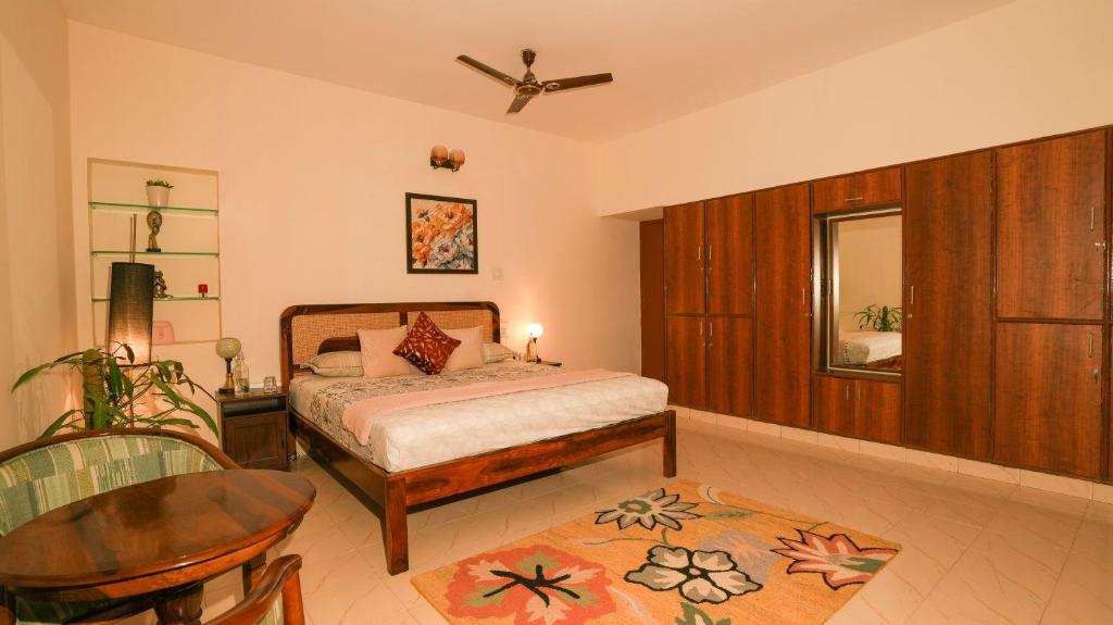 a bedroom with a bed and a table and a mirror at Luho White House in Bangalore