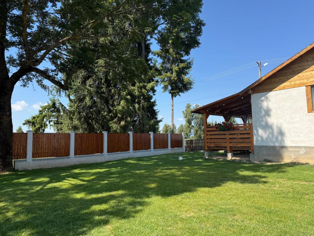 a yard with a fence and a wooden bench at Cabana Eduard in Rişca