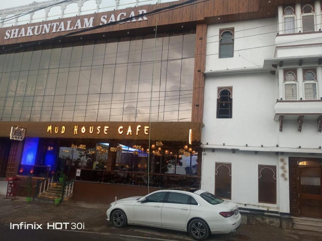 a white car parked in front of a building at Shakuntalam Hotels in Udaipur