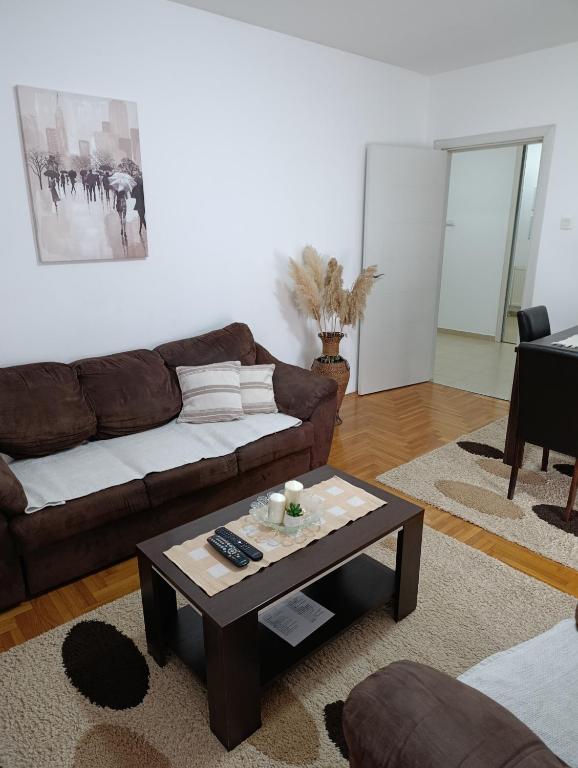 a living room with a couch and a coffee table at Sirmijum Hause II in Sremska Mitrovica