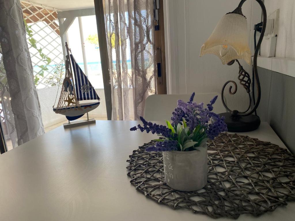une table avec un vase avec des fleurs violettes dessus dans l'établissement Mackenzie By the sea one bed Ground floor home, à Larnaka