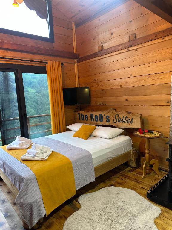 a bedroom with a bed in a room with wooden walls at The Reo's Suit in Çayırdüzü