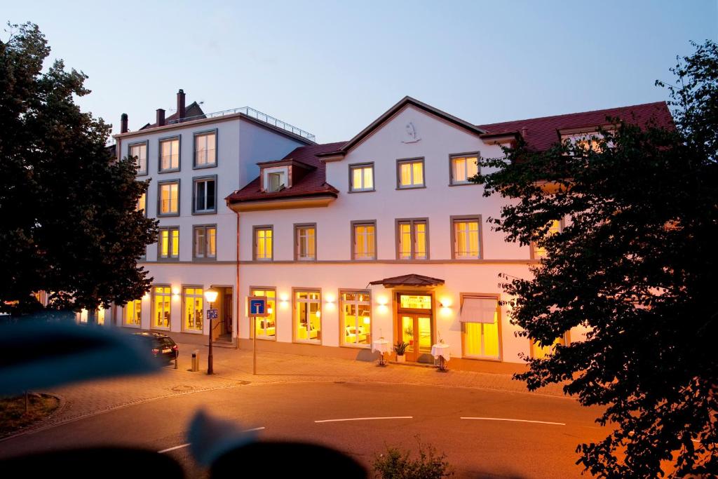 a large white building with its lights on at Hotel Constantia in Konstanz