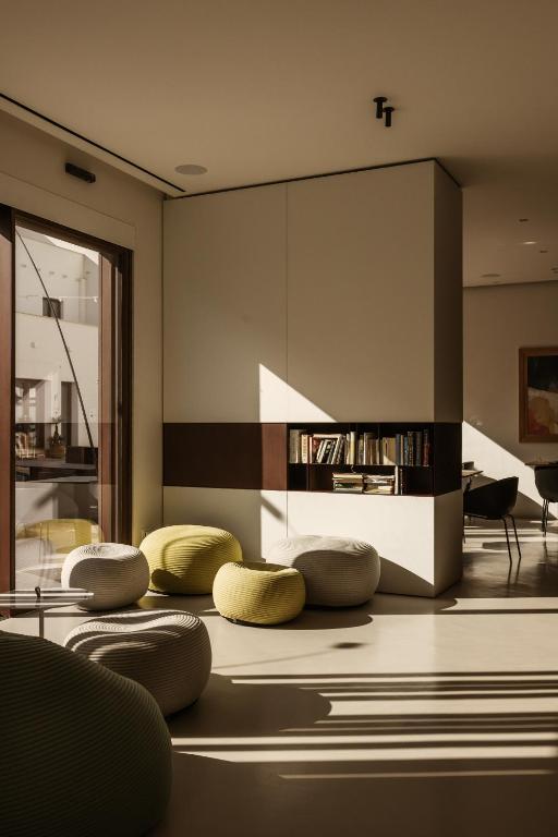 a living room with yellow chairs and a fireplace at Hotel Tannure in San Vito lo Capo