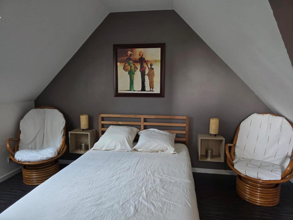 una camera da letto con un letto e due sedie di Logement sur la Loire à vélo a Montlouis-sur-Loire