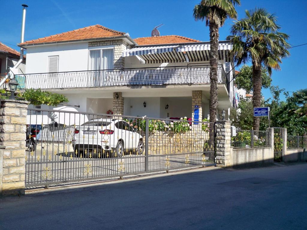 a white car parked in front of a house at Apartment Vlado in Sukošan