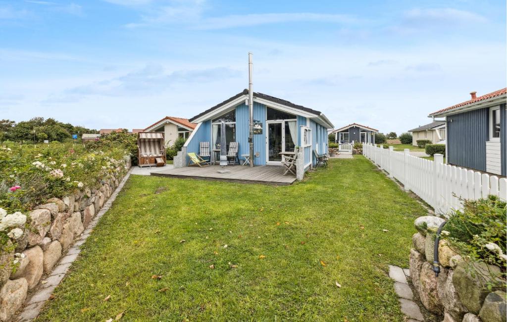 a blue house with a fence and a yard at Friedrichskoog-Deichblick 4 in Friedrichskoog