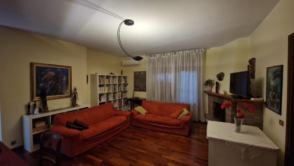 a living room with two orange couches and a television at Civico 51Appartamento a Sassuolo in Sassuolo