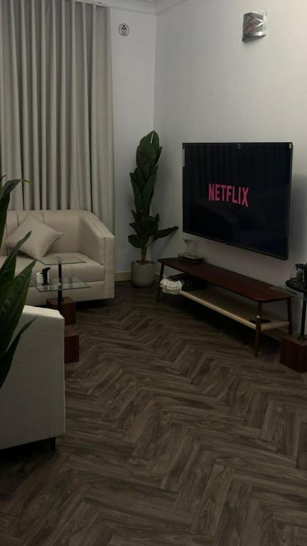 a living room with a flat screen tv and a couch at منازل سمو in Buraydah