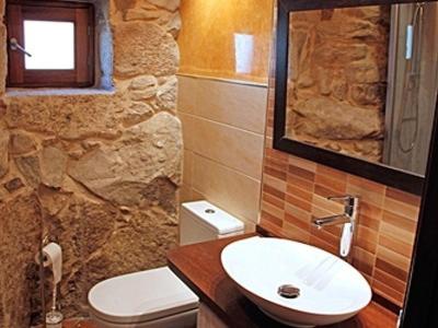 Baño de piedra con lavabo y aseo en Casa Noelmar, en Combarro