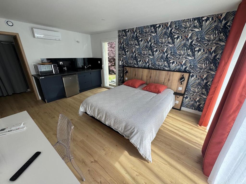 a bedroom with a bed with two red pillows on it at Studio La Salamandre in Plauzat