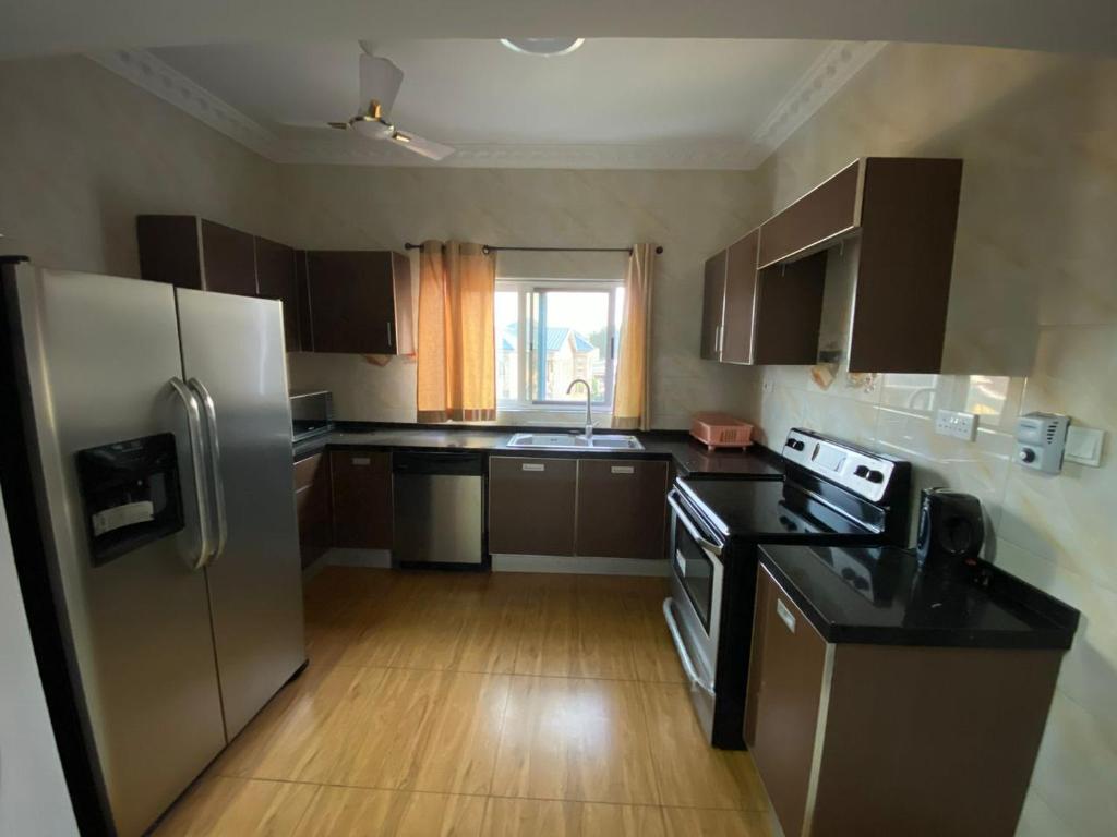 a kitchen with a stainless steel refrigerator and wooden floors at The Edge in Accra