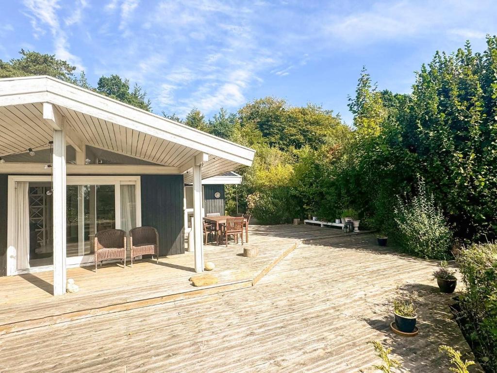 a wooden deck with a table and chairs on it at 6 person holiday home in Dronningmølle-By Traum in Hornbæk