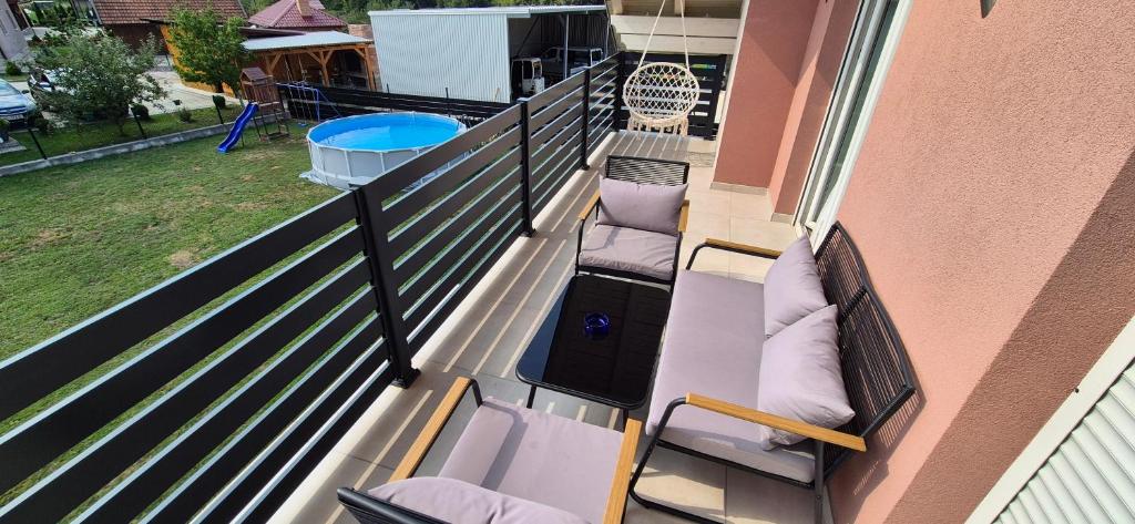 ein Balkon mit zwei Stühlen und ein Pool in der Unterkunft Apartman Swans in Otočac