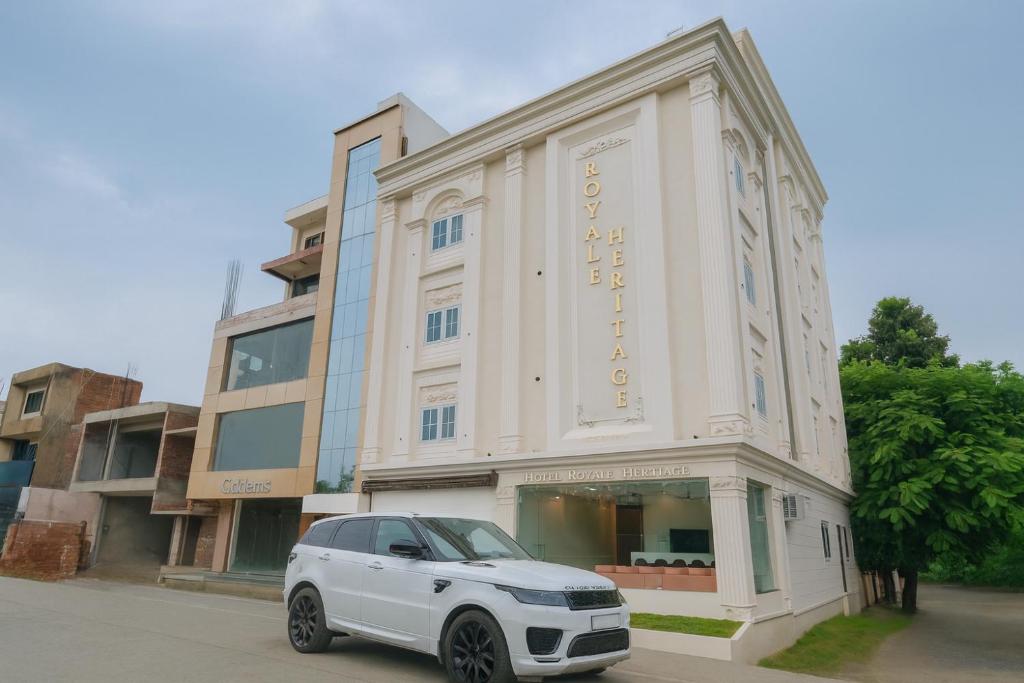 a white car parked in front of a building at Hotel Royale Heritage in Ujjain