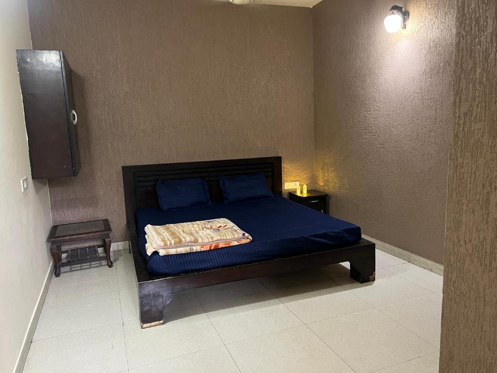 a bedroom with a bed with blue sheets and a speaker at Bite of Life Cafe and Resort in Dehradun