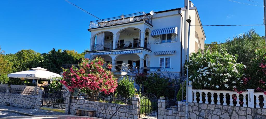 a white house with a fence in front of it at Apartments Desiree & Daniel in Dramalj
