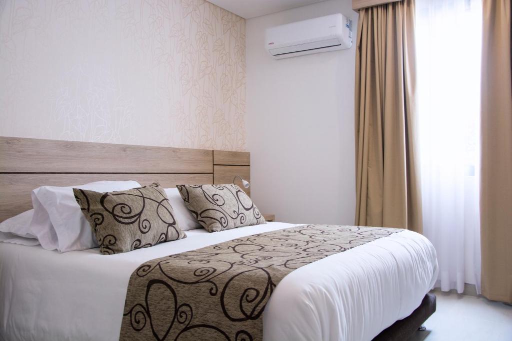 A bed or beds in a room at Hotel Arawak Plaza