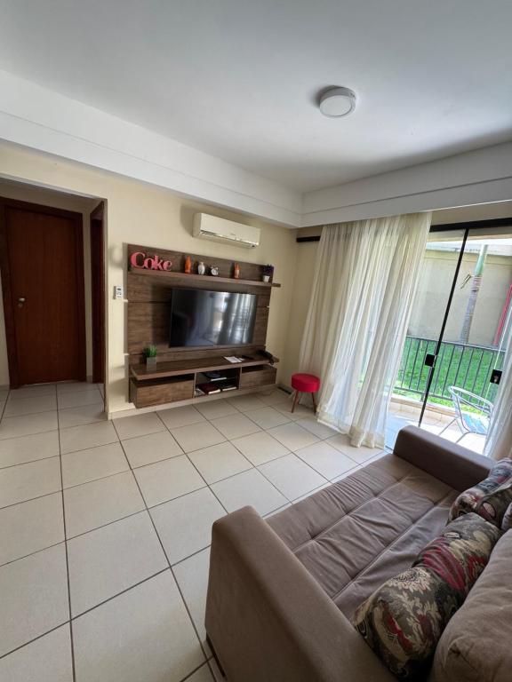 a living room with a couch and a flat screen tv at Apartamento aldeia das águas in Barra do Piraí