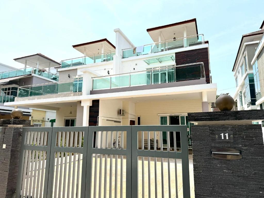 a white house with a gate and a fence at Mutiara Gurney at 15, Lorong Kelawai in George Town