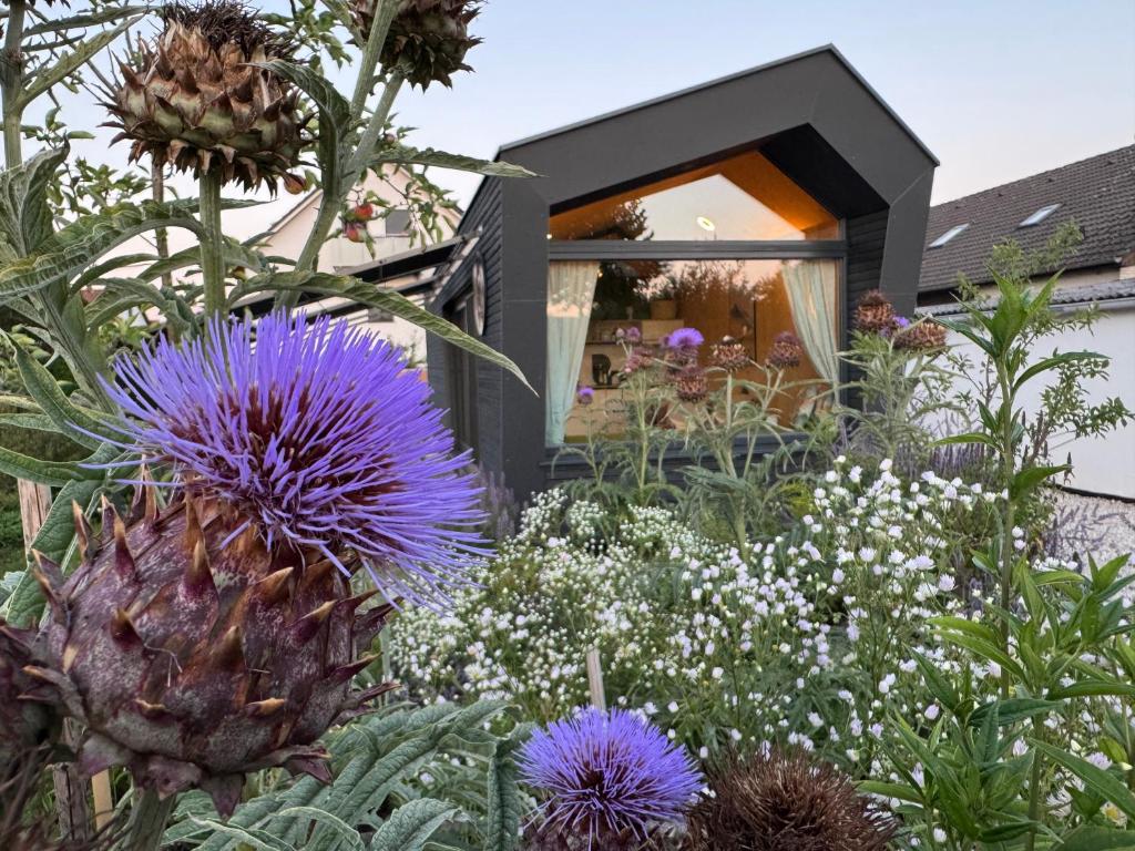 a garden with flowers in front of a house at Draußendrin Cabin im schönen Altmühltal in Kelheim