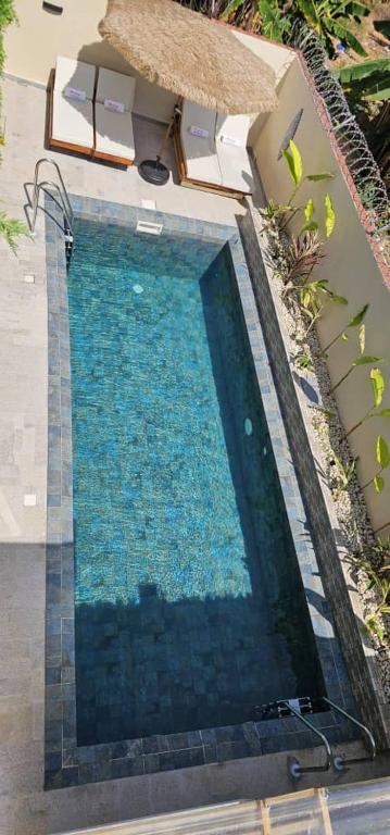 ein Swimmingpool mit blauem Wasser vor einem Haus in der Unterkunft Villa Diniyo in San-Pédro