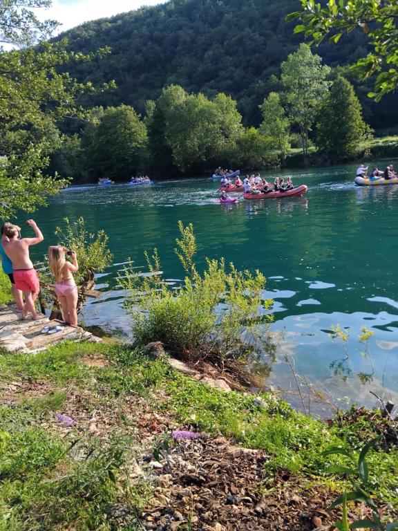 two children playing in the water on a river at Apartmani Nurka in Orašac