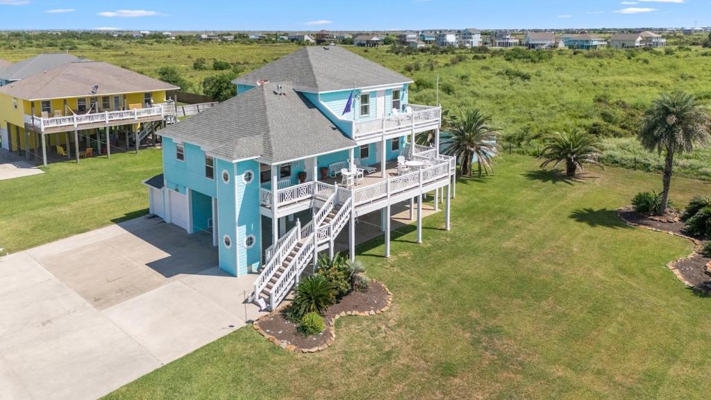 Una vista aérea de una casa azul con una escalera. en Views, 3 King Suites, 15 Guests, en Bolivar Peninsula
