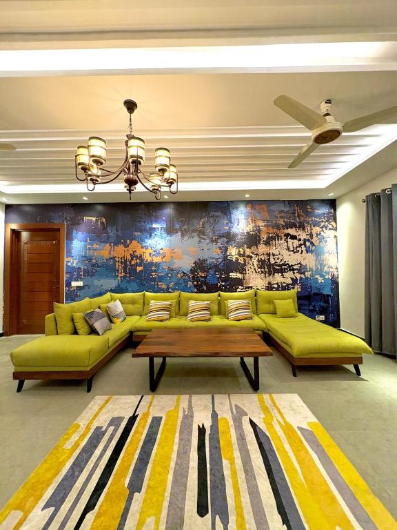 una sala de estar con un sofá y una mesa en The Grand Haven - 3BHK, en Islamabad