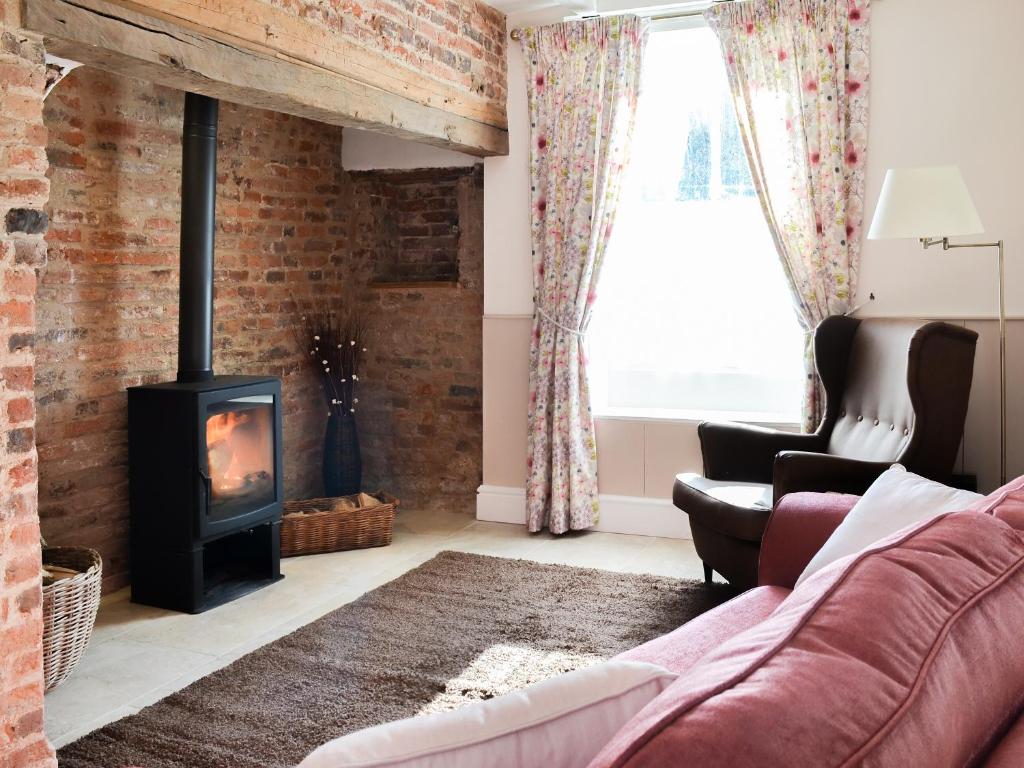 a living room with a brick wall and a wood stove at West House Farm in Filey