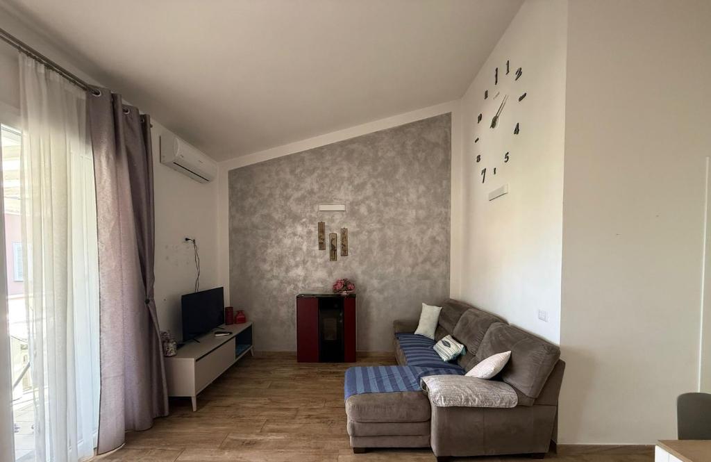 Una sala de estar con un sofá y un televisor. en Il Frutteto Barbarossa, en Porto Azzurro