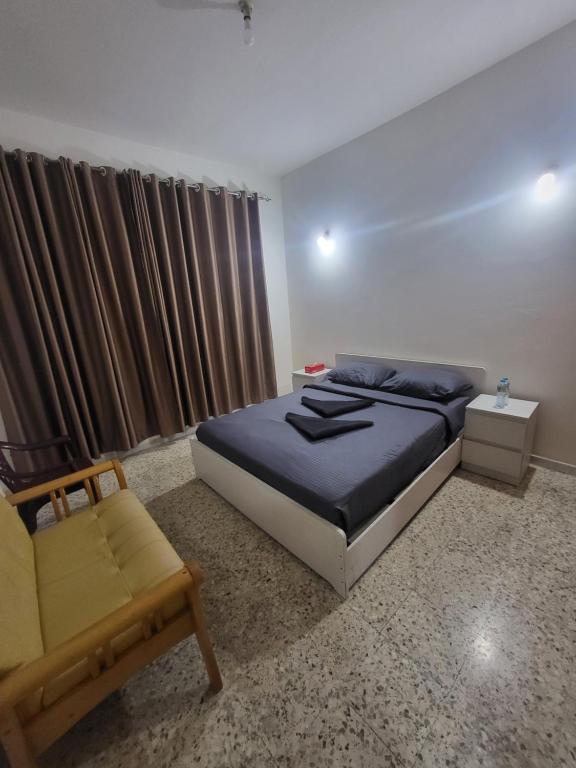 a bedroom with a bed and a chair at Liberty Studio Apartments in Abu Dhabi