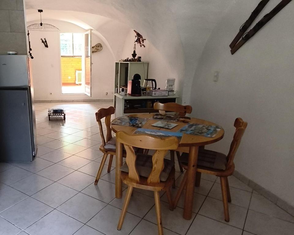 Una cocina con mesa y sillas y un refrigerador. en Au pied des stations, en Sainte-Marie-de-Cuines