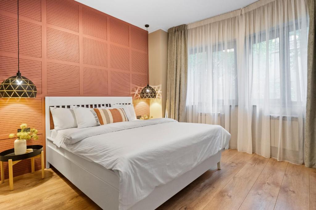 um quarto com uma cama branca e uma janela grande em Tova Pearl - Cozy, Modern 2BR Apt, DT, Ultracentral, Chabad across street, 20 min walk to Old Town em Bucareste