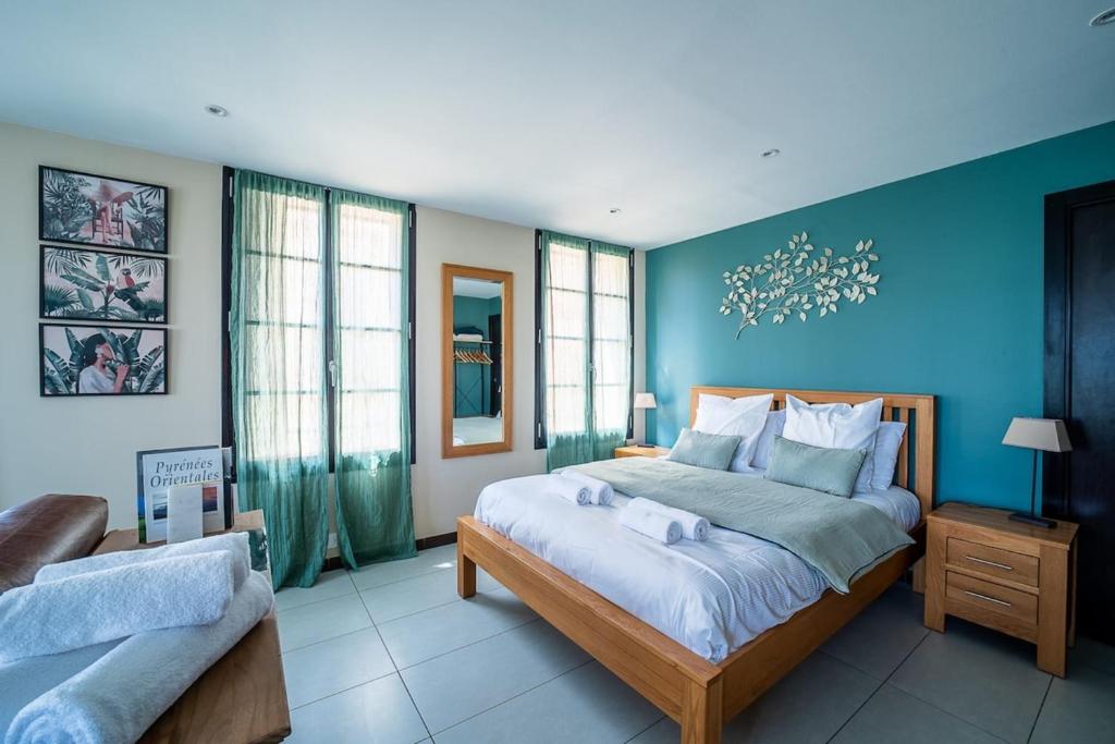 佩皮尼昂Coronell d'En Vila的卧室里有一张大床，墙壁是蓝色的