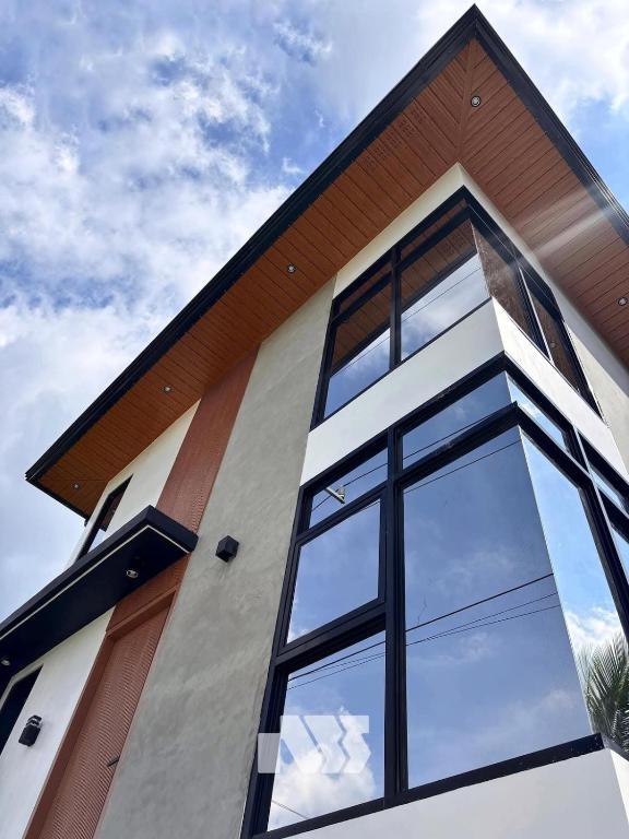 une maison avec de grandes fenêtres sur le côté dans l'établissement ZMZ Silang Transient House near Tagaytay, à Silang