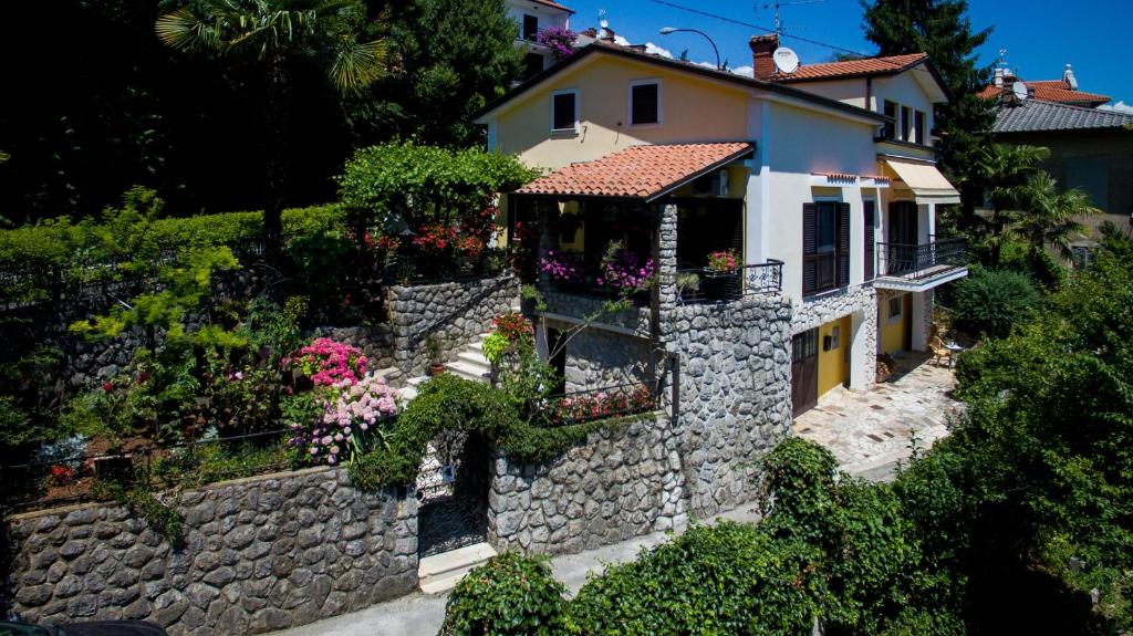a house with flowers on a stone wall at Apartment Dolores in Opatija