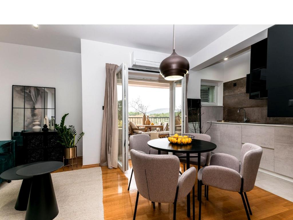 a kitchen and living room with a table and chairs at Calidum Boutique Suites in Šibenik