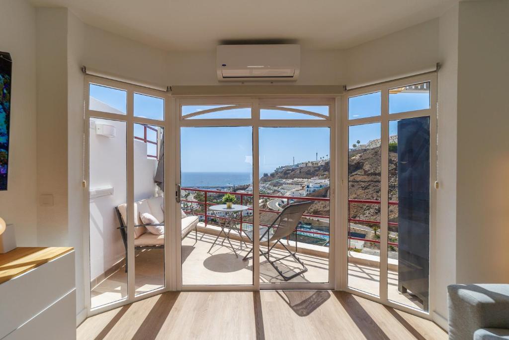 a room with a balcony with a view of the ocean at Guanabara Sunset in Puerto Rico de Gran Canaria