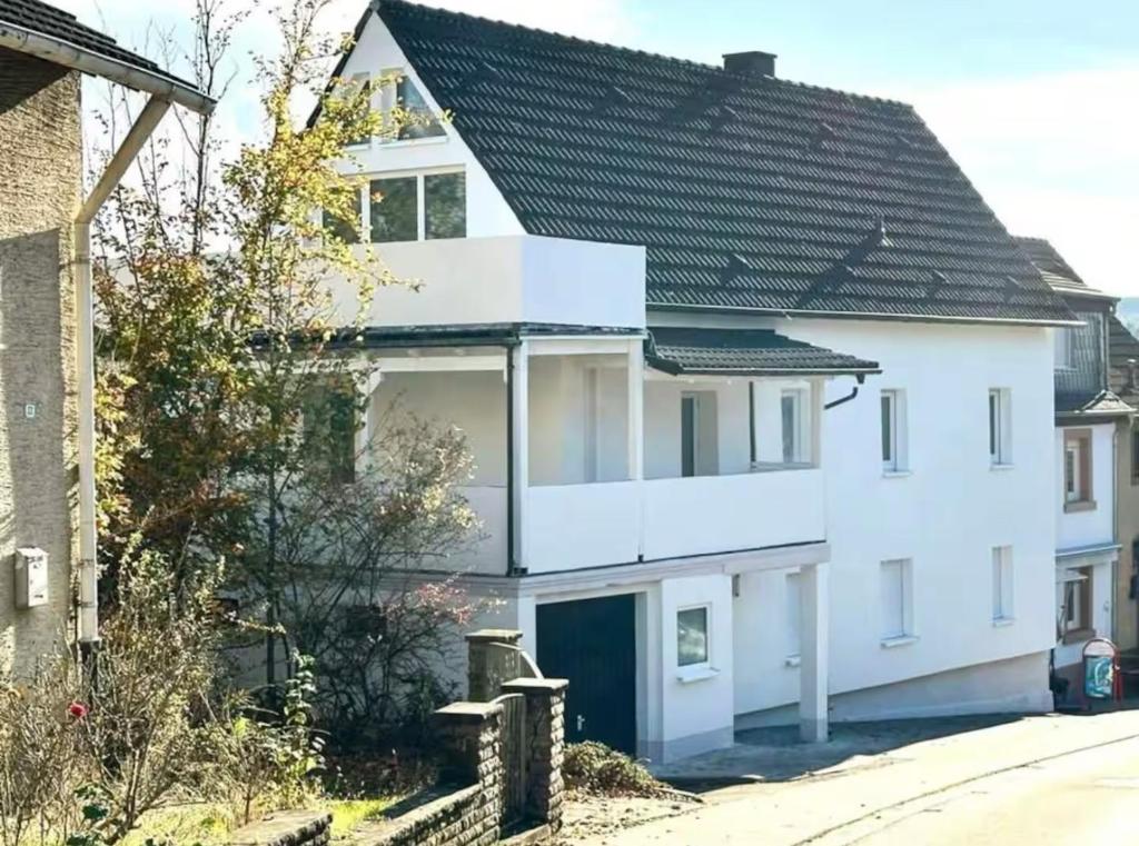 a white house with a black roof at Sehr gut ausgestattetes Einfamilienhaus in Hochspeyer