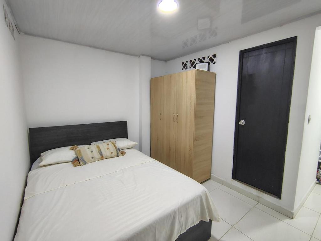 a bedroom with a bed and a wooden cabinet at Apartamento en Aranjuez cómodo y tranquilo in Medellín