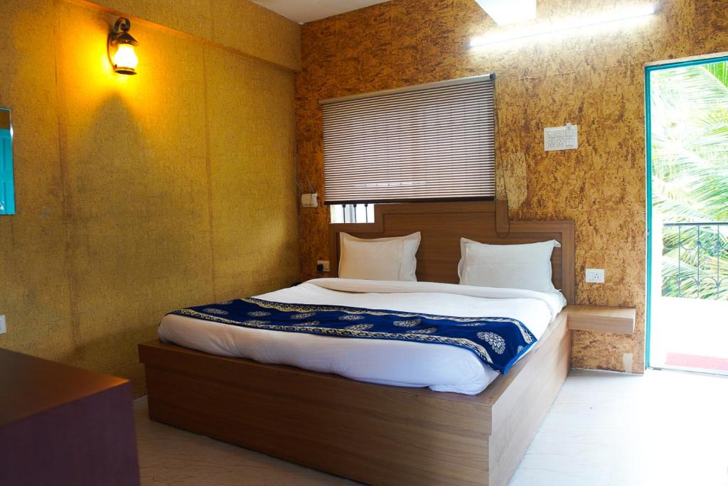 a bedroom with a large bed in a room at Baga Blue Marine Beach Resort in Baga