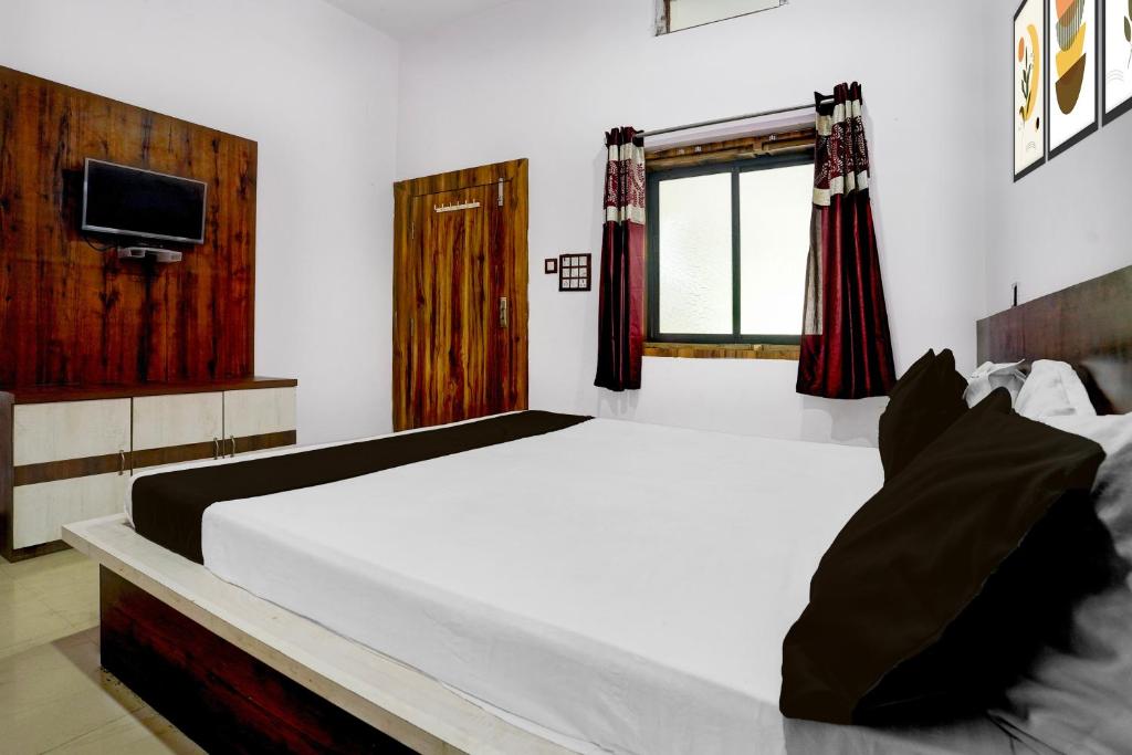 BilāspurにあるHotel O Pushkar And Restaurantの大きな白いベッドとテレビのある寝室